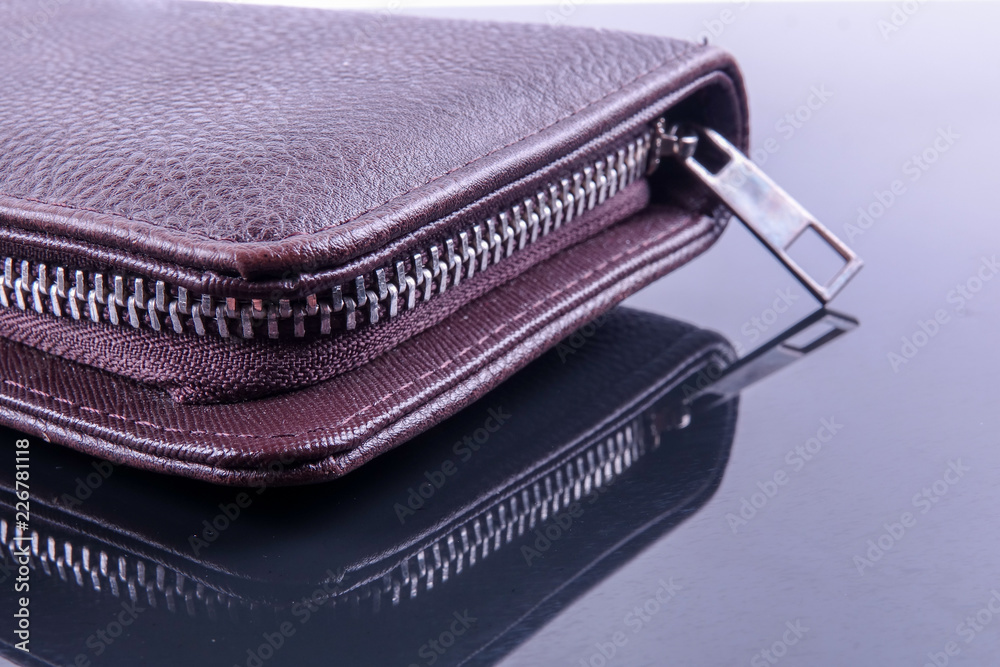 A brown men's leather wallet with reflection. A brown men's leather wallet with reflection.