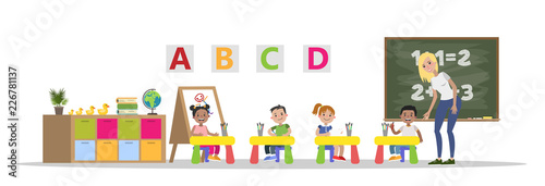 Preschool kids study in classroom with teacher