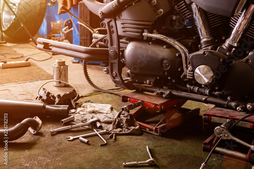 Cropped close up shot of beautiful and custom made motorcycle in the workshop photo