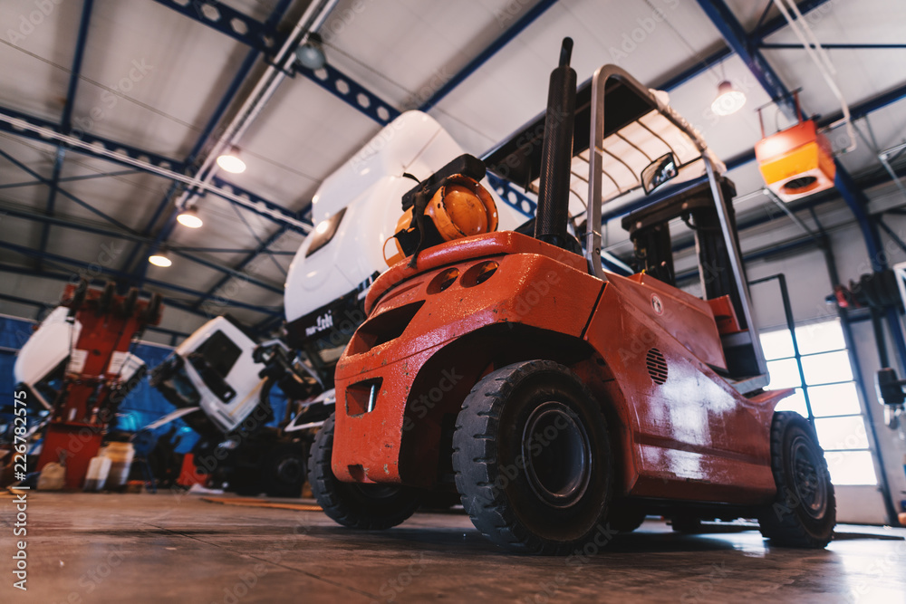 Picture of forklift in car repairing workshop. Picture of forklift in car repairing workshop.