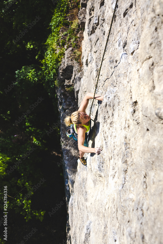 The girl climbs the rock.