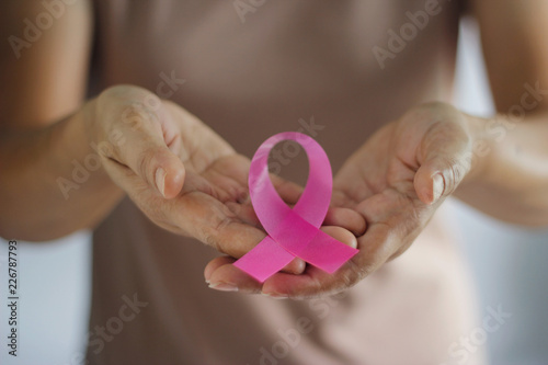 Breast Cancer Awareness Concept.  Health care and medical. Hand of woman holding pink ribbon awareness symbol for endometriosis, Medicine. Prevention Breast..