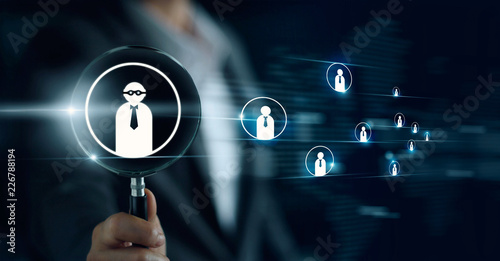 Businessman holding magnifying glass, searching for good and quality employees. officer looking for employee represented by icon. Recruitment, CRM, human resource, HR, teamwork concept.