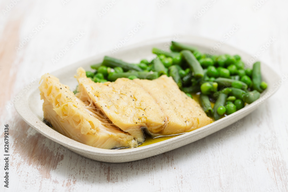 cod fish with green beans and peas on dish