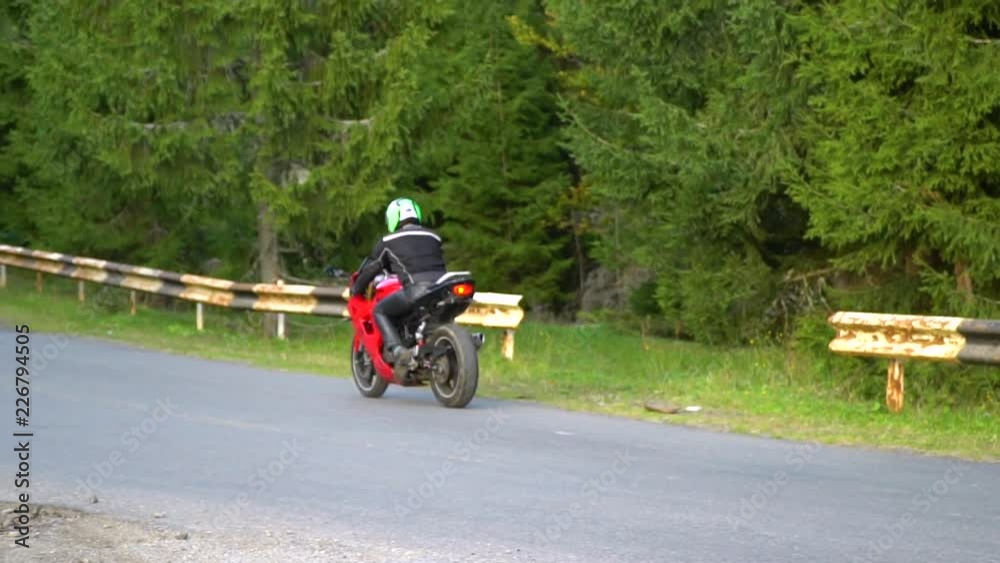 A guy on a motorcycle. Young handsome guy rides a motorcycle on a mountain road. A guy on a motorcycle. Young handsome guy rides a motorcycle on a mountain road.