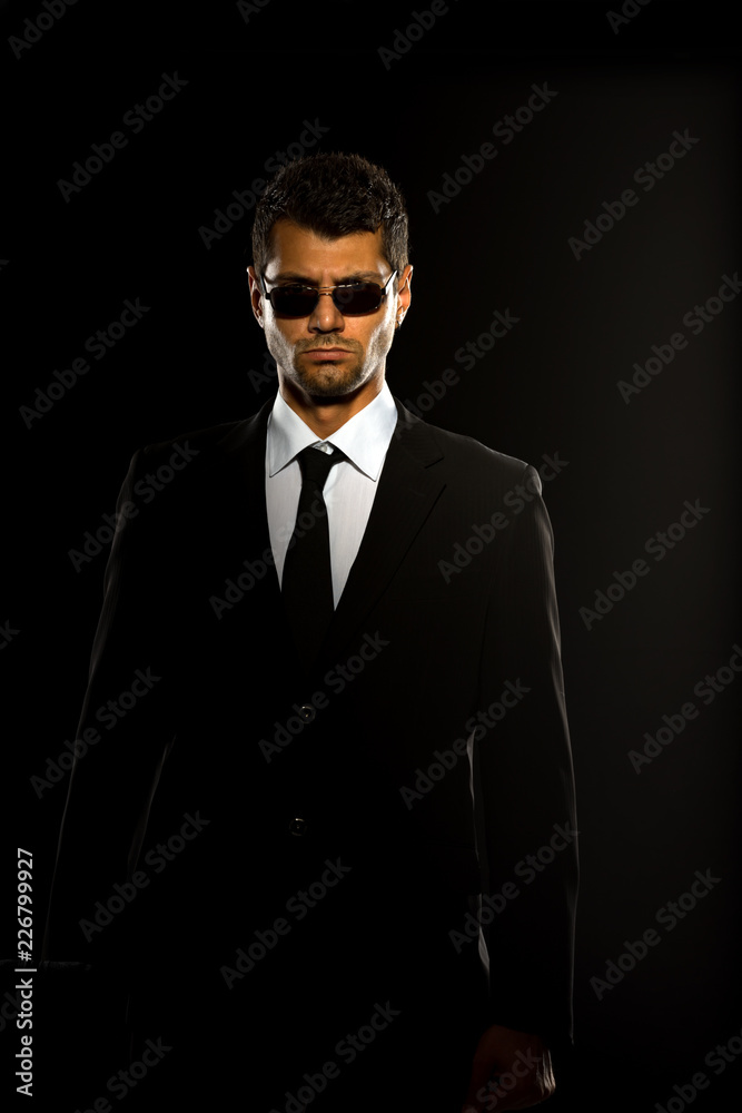 A serious man in a black suit.