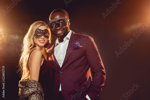 happy multicultural couple in carnival masks for new year party