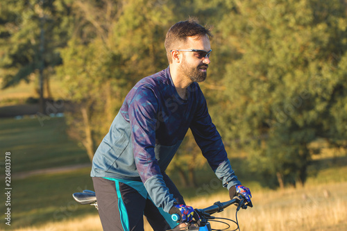 A cyclist rides the hills, Beautiful portrait of a guy on a blue bicycle 