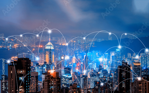 Digital network connection lines of Hong Kong Downtown and Victoria Harbour. Financial district in smart city in technology concept. Skyscraper and high-rise buildings. Aerial view at night. photo