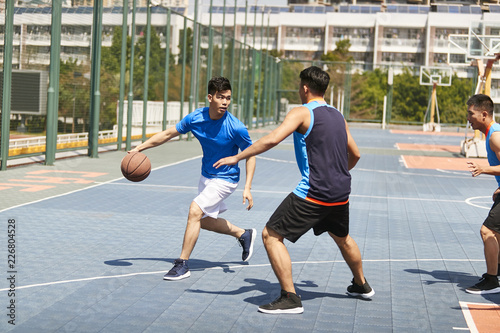 young asian adults playing basketball
