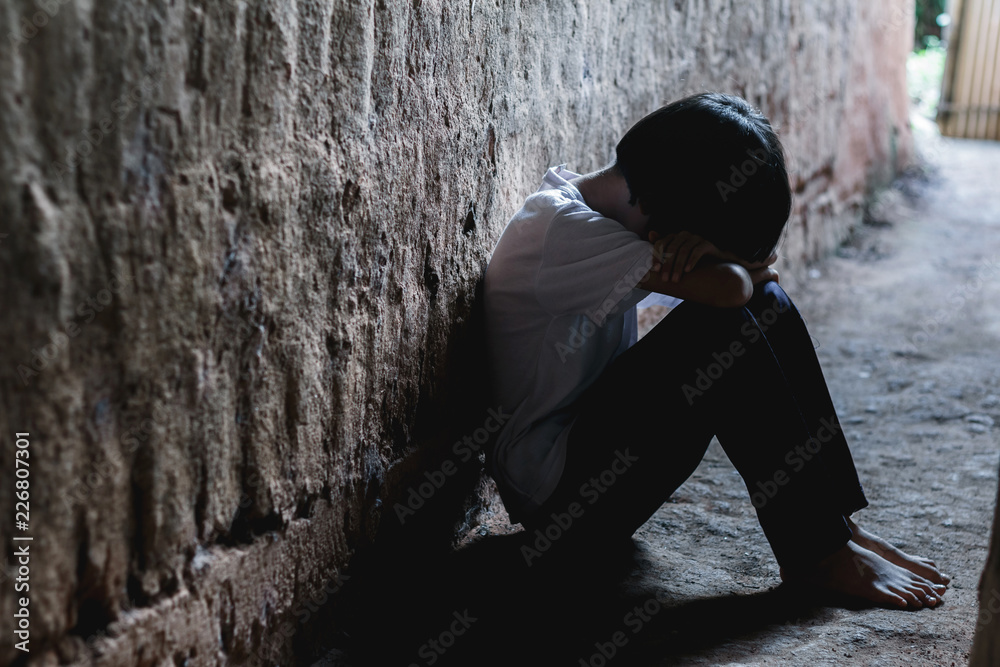 Helpless girl sitting on floor against old earth brick wall,children violence and abused concept,human trafficking concept Helpless girl sitting on floor against old earth brick wall,children violence and abused concept,human trafficking concept