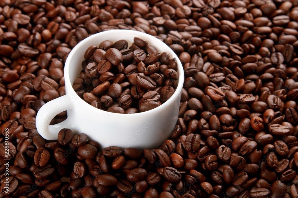 Mug full of, and surrounded by, coffee beans Mug full of, and surrounded by, coffee beans