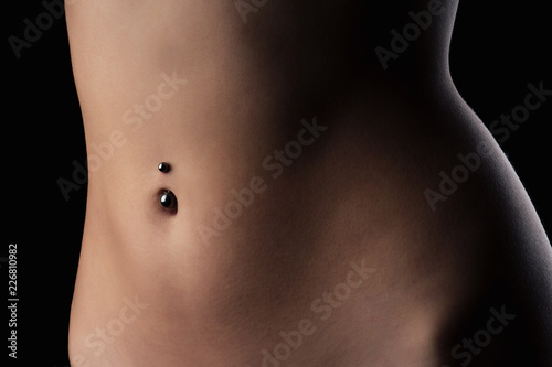 perfect female body Navel piercing erotic photoshoot on black background in studio shot