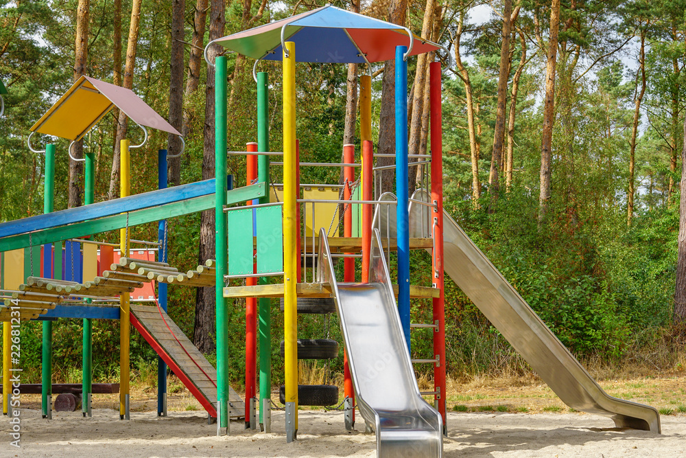 Children playground on yard activities in public park surrounded by green trees at sunlight morning. Children playground on yard activities in public park surrounded by green trees at sunlight morning.