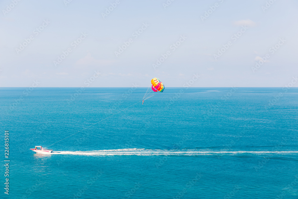 Parasailing at Chaweng Beach in Samui - Thailand extreme Sport. Tourists parasailing - popular entertainment for holiday travelers on Chaweng Beach in Samui, Thailand.