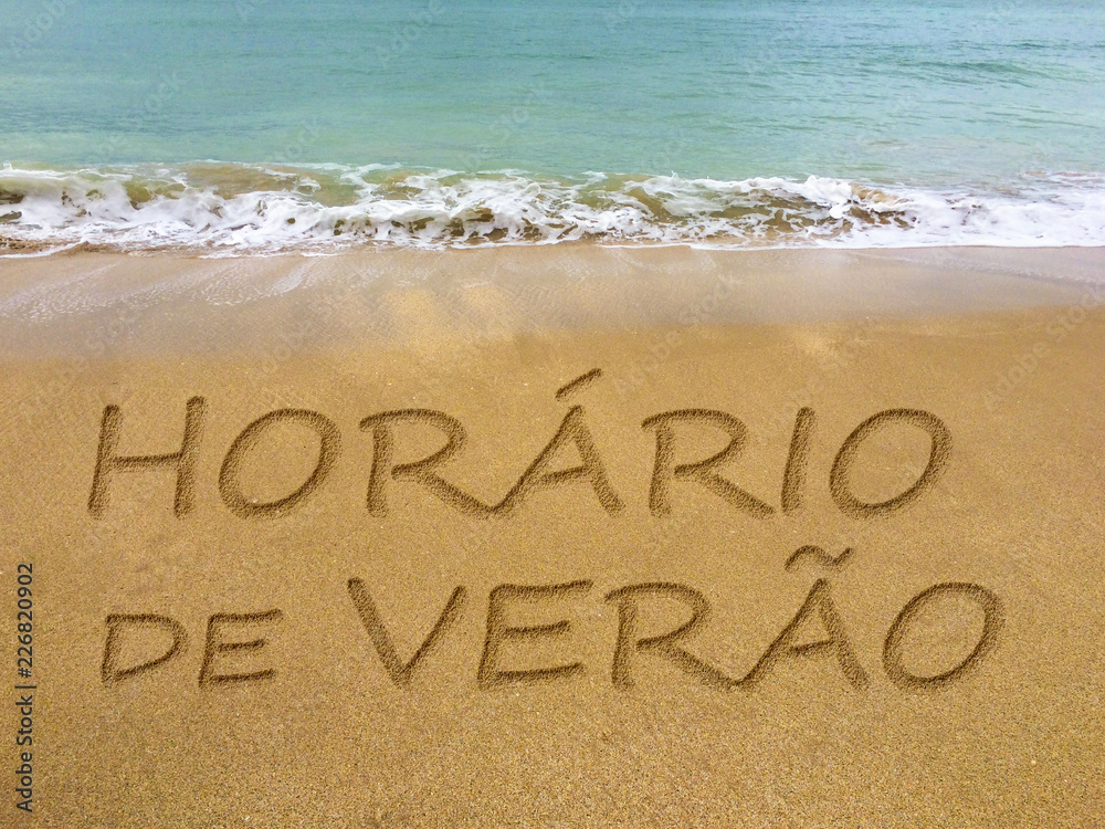 Fototapeta premium Summer time written in the sand on a beautiful Brazilian beach (translation portuguese: summer time).