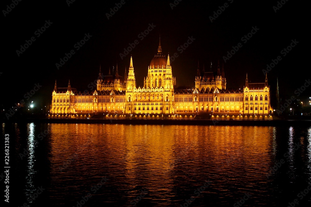 Parlamento de Budapest iluminado en la noche y reflejo en el río Danubio