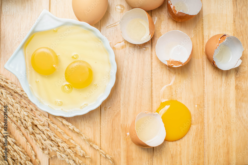 Fresh farm eggs on a wooden background. separated egg white and yolk. Eggs in bowl for cooking omelet. Fresh farm eggs on a wooden background. separated egg white and yolk. Eggs in bowl for cooking omelet.