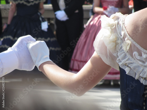 Close up of couple hands in white gloves during historical dance . Loveliness and prettiness couple of dancers