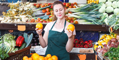 seller woman is demonstraiting oranges