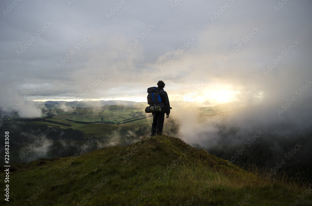 Hiker Watching the Sunset up in the Hills