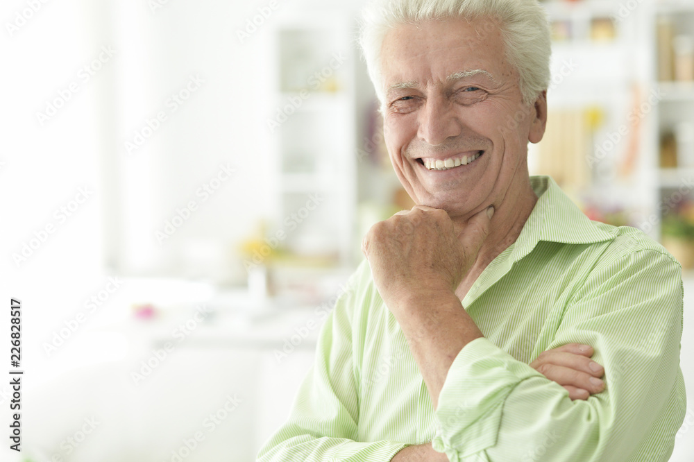 Portrait of smiling senior man in kitchen Portrait of smiling senior man in kitchen