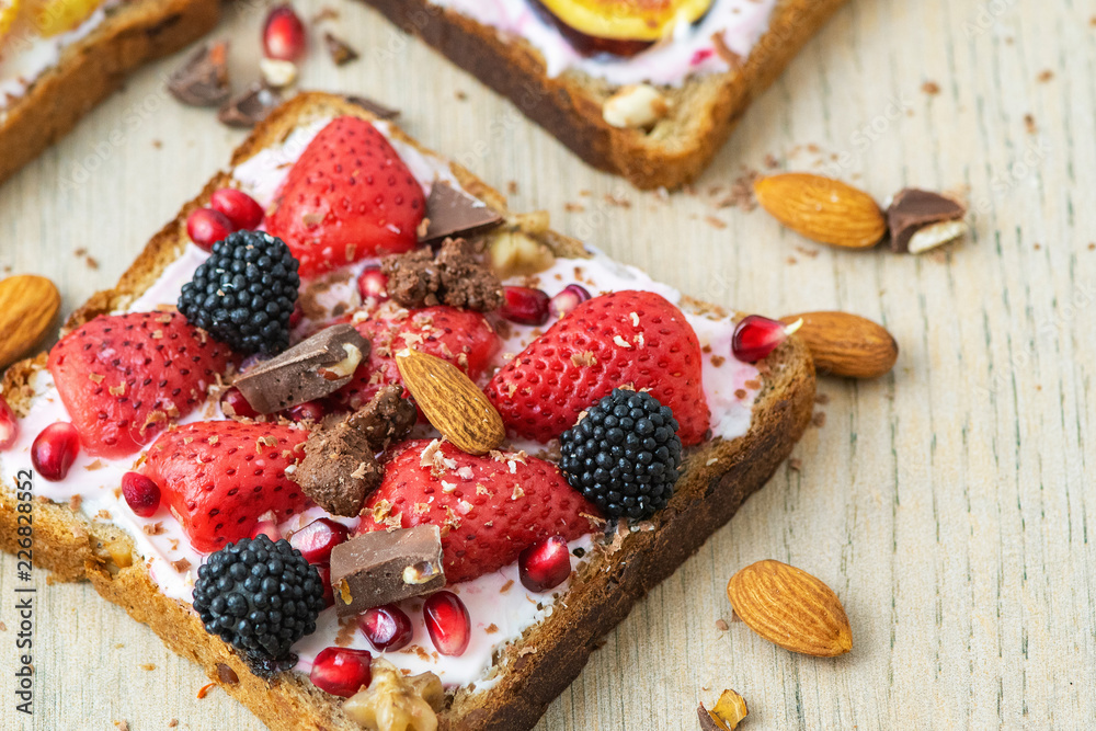 Healthy breakfast. Slice of wholegrain toast with cream cheese, strawberrys, nuts and BlackBerry. Top view