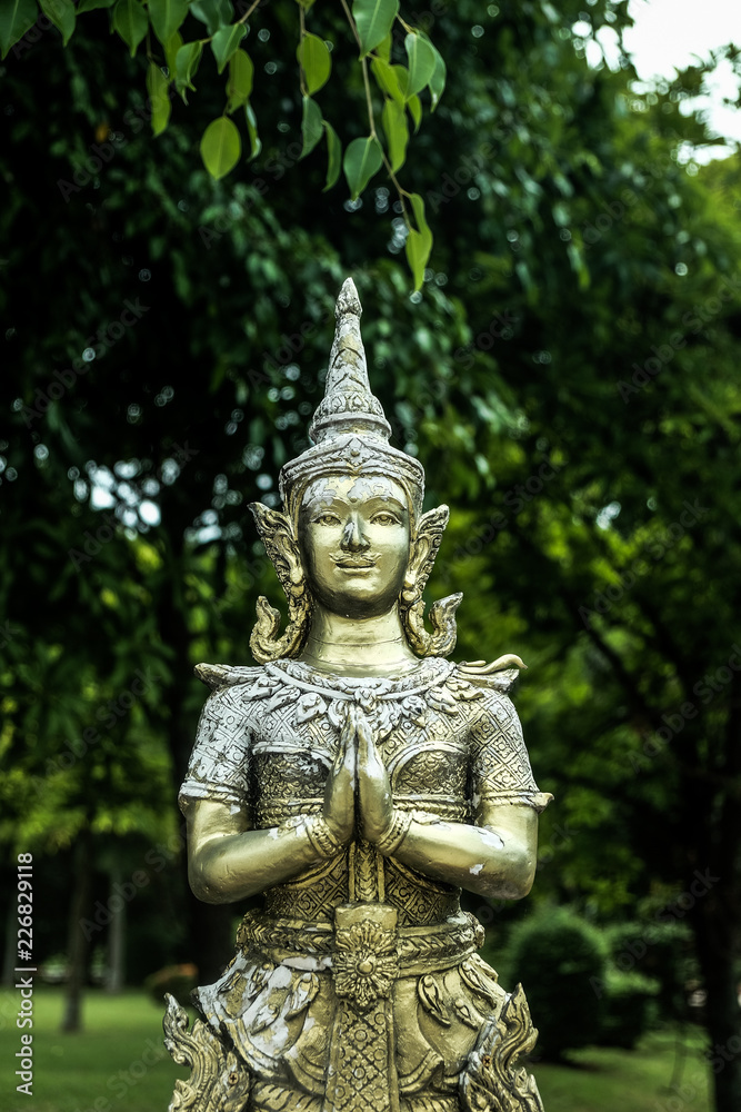 The golden figure of a deva clasping hands in token of worship The golden figure of a deva clasping hands in token of worship