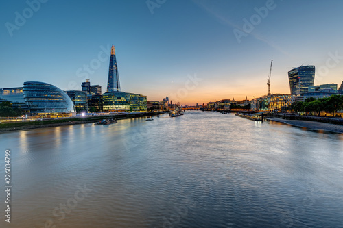 View of the river Thames in London after sunset with the skyscrapers of the City and the Tower