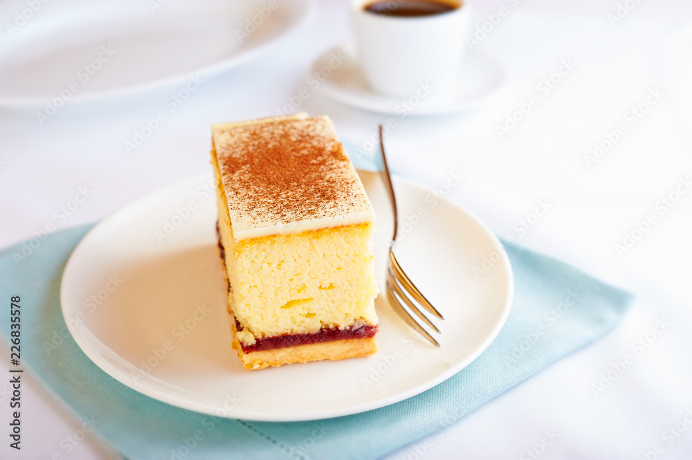 Cheesecake with white chocolate and cocoa and a cup of coffee. White background. Copy space. Cheesecake with white chocolate and cocoa and a cup of coffee. White background. Copy space.