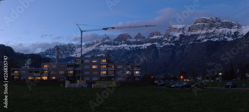 Churfirsten from Flums at dusk, showing lights of apartments by railway station, Swiss Alps photo