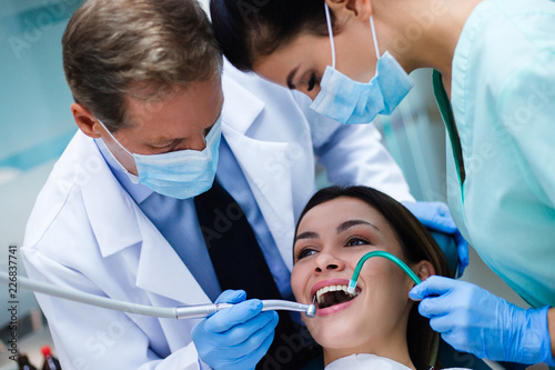 Everything must be perfect  Top view of dentist with his assistant examining his patient in dentist   s office