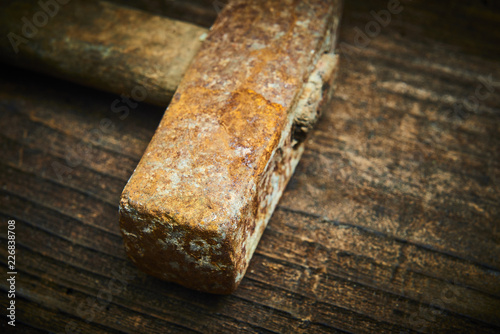 Close up of old used hammer on a rustic wooden background. Selective focus