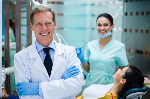 Your dream team. Cheerful dentist looking at camera with smile while standing in dentist’s office