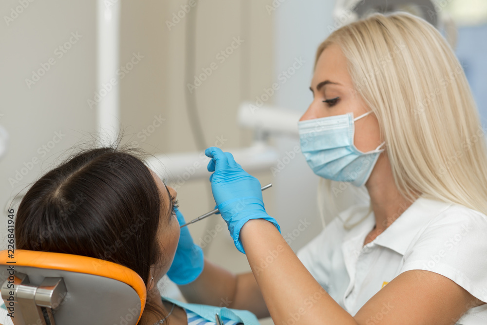 Pretty girl having mouth checkup in hospital by professional female dentist Pretty girl having mouth checkup in hospital by professional female dentist