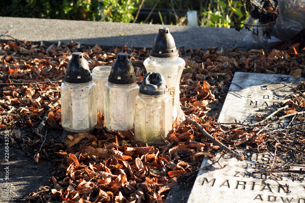 Obraz premium Cmentarz - stary grób, znicze i liście