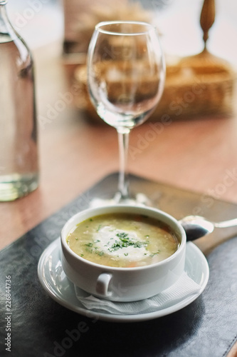 Bowl with soup served with glass .Delicious business lunch menu in cafe.