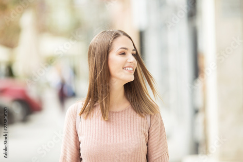 Young beautiful woman outdoors on the street smiling Free Download Young beautiful woman outdoors on the street smiling - GFXLoad