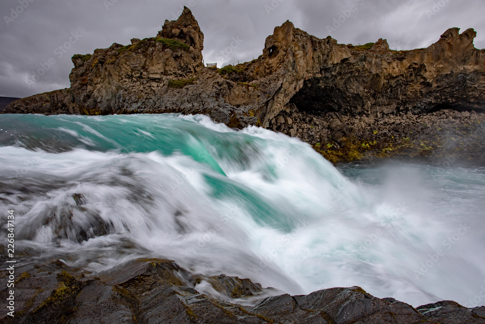 Fototapeta premium Icelandic waterfall in Icelandic natural landscape. Famous sights and attractions in Icelandic natural landscape on Southern Iceland