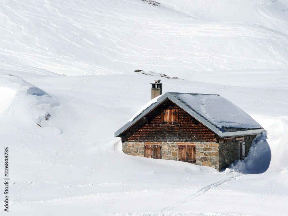 Cow Stable sunk in the deep snow on the Alps mountain in winter