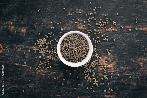 Lentil. On a black wooden background. Top view. Free copy space.