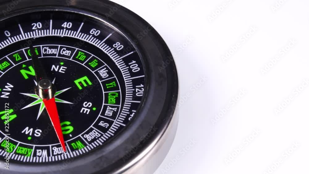 Close up compass rotating on white background. Travel, tourism and exploration Close up compass rotating on white background. Travel, tourism and exploration