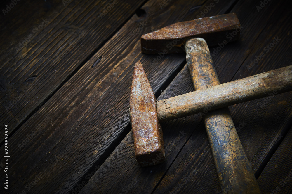 Close up of two old used hammer on a rustic wooden background. Selective focus Close up of two old used hammer on a rustic wooden background. Selective focus