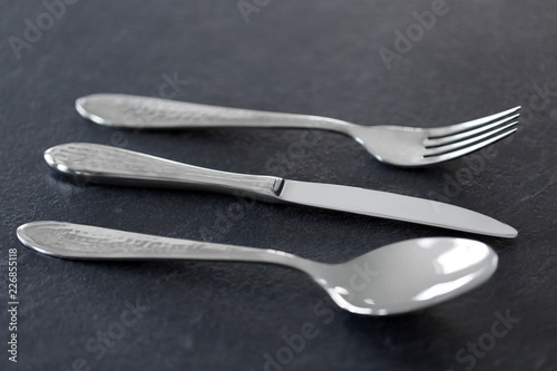 table setting, cutlery and eating concept - close up of fork, knife and spoon