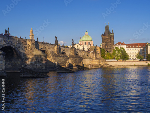 View of Charles Bridge in Prague, Czech Republic. Gothic Charles Bridge is one of the most visited sights in Prague. Architecture and landmark of Prague, golden light, sunny summer day