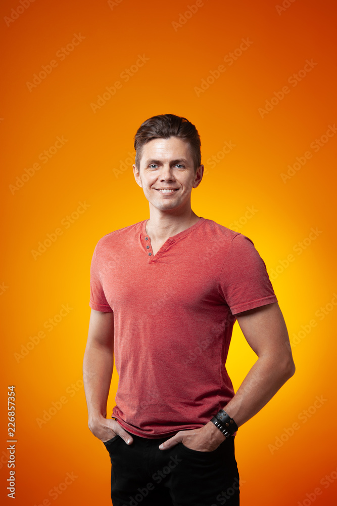 Adult cheerful man smiling on an orange background Adult cheerful man smiling on an orange background