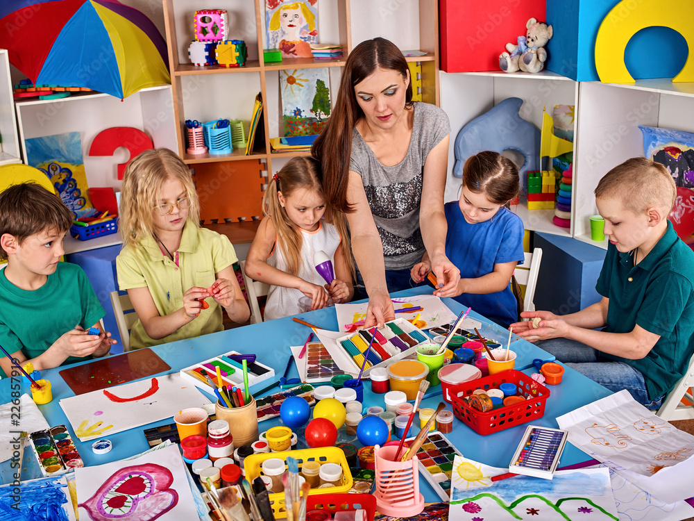 Fototapeta premium Plasticine modeling clay in children class. Clay projects with teacher teaches kids together play dough and mold in kindergarten or preschool.