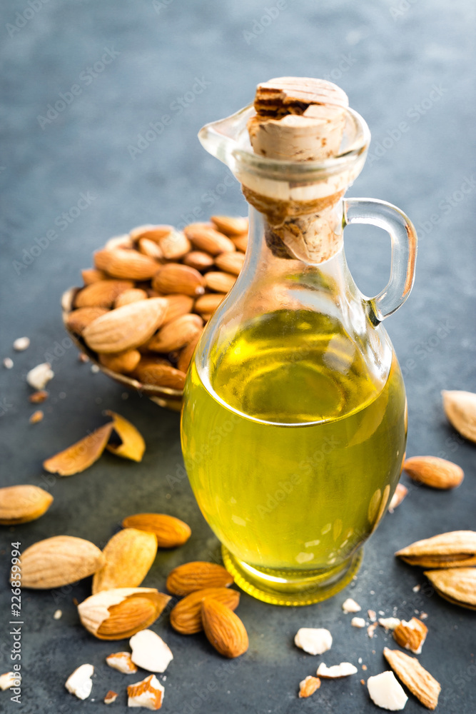 Almond oil in glass bottle and almond nuts. Almonds Almond oil in glass bottle and almond nuts. Almonds