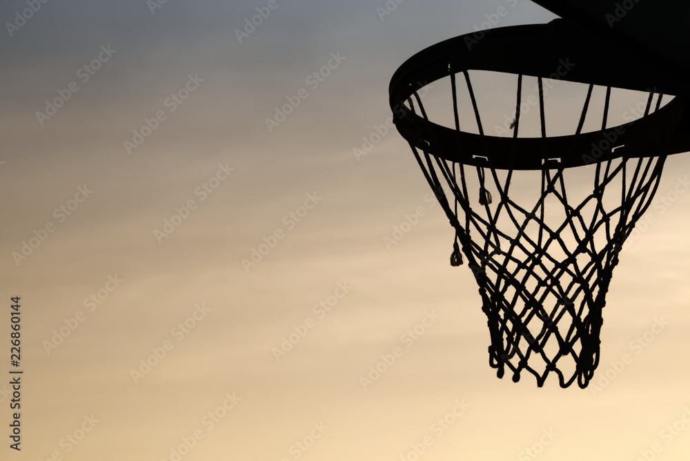 Basketball hoop silhouette in the sunset. cirrostratus clouds background