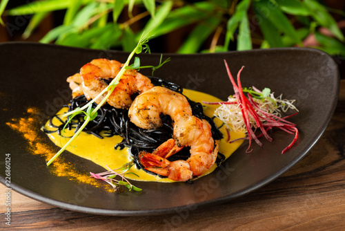 Thai fine dining/ Fresh cilantro marinated “Black Tiger” shrimps and mango sauce on black noodles photo